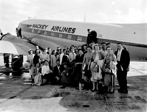 Women's Glee Club members stand by a plane before an international performance trip to Nassau.